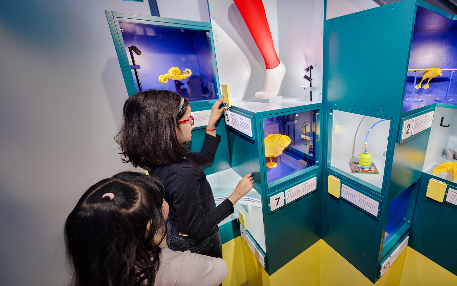 Children exploring interactive science exhibits with colorful displays.