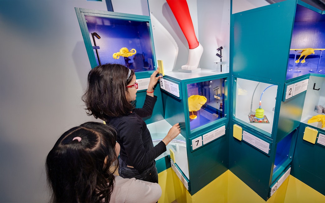 Children exploring interactive science exhibits with colorful displays.