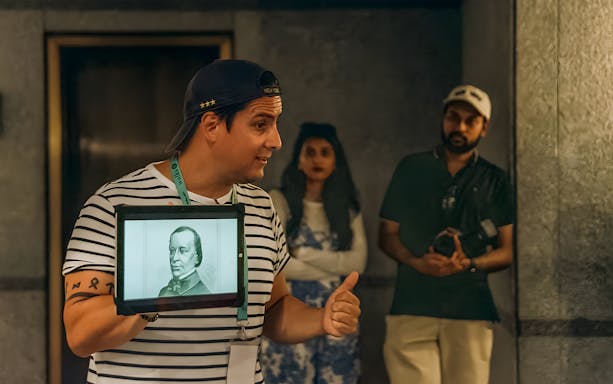 Tour guide presenting historical image during Statue of Liberty and Ellis Island tour.