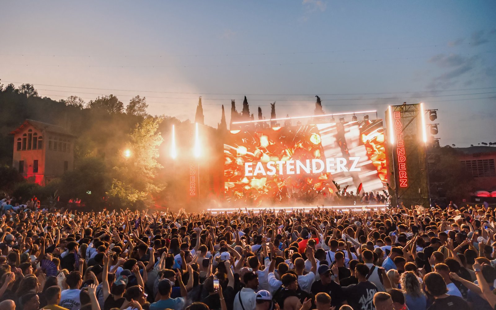 Crowd enjoying Eastenderz performance at outdoor venue in Ibiza.