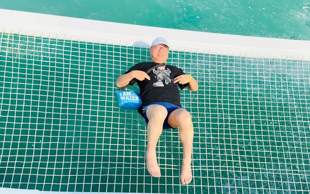 Man relaxing on a jacuzzi net during Langkawi Island hopping tour.