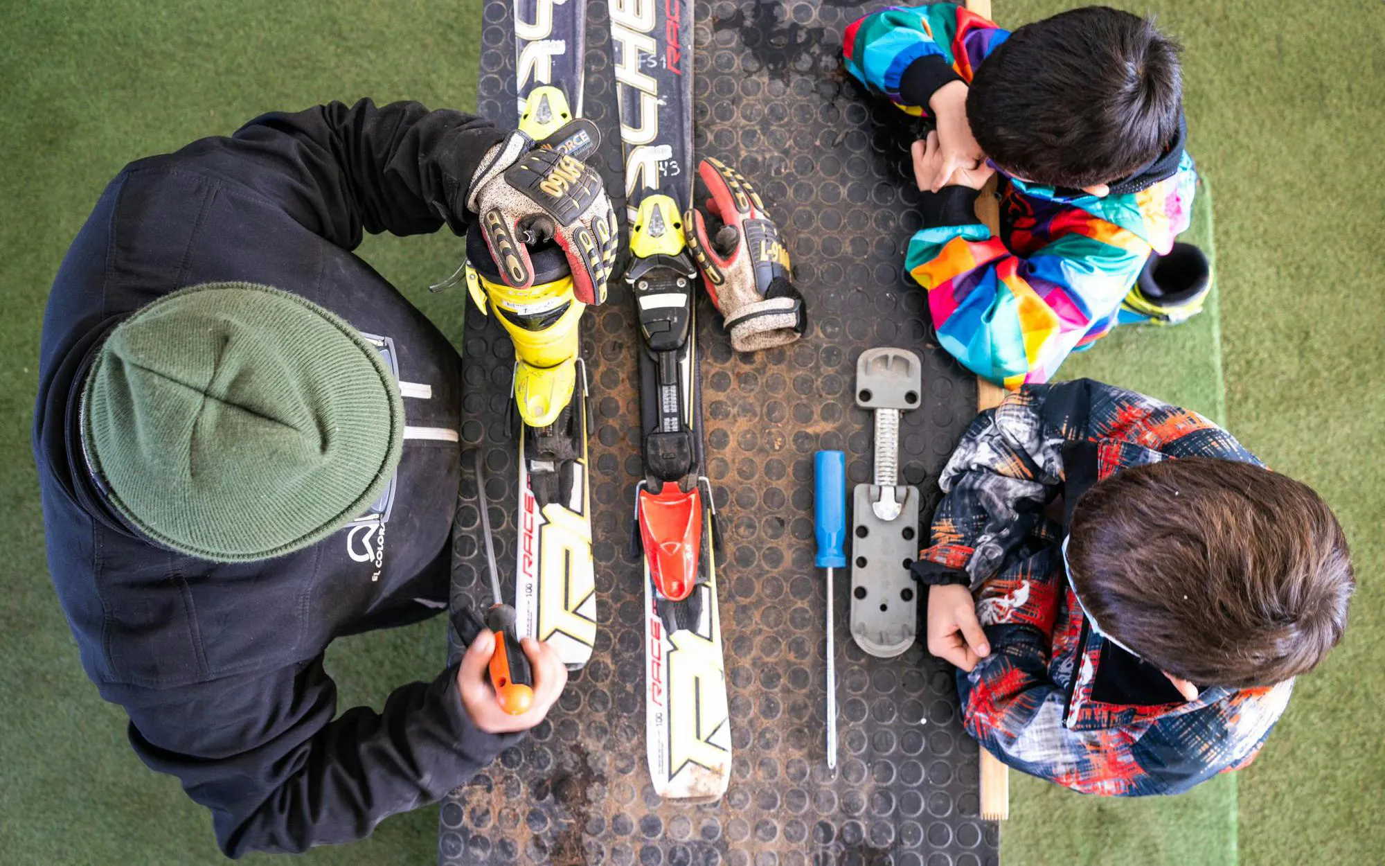 Person adjusting Fischer skis with tools in Chile.