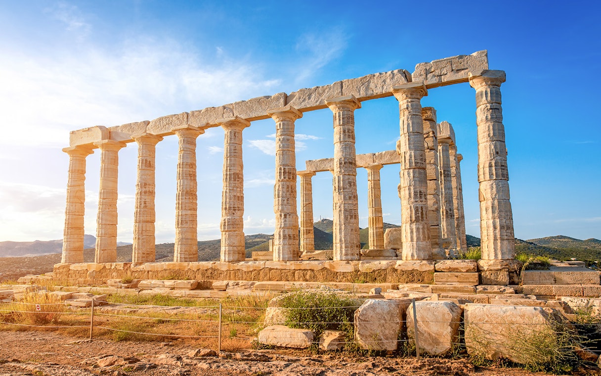 Ancient Temple of Poseidon at Cape Sounion, Greece, with clear blue sky.