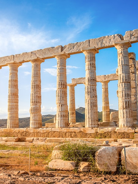 Ancient Temple of Poseidon at Cape Sounion, Greece, with clear blue sky.