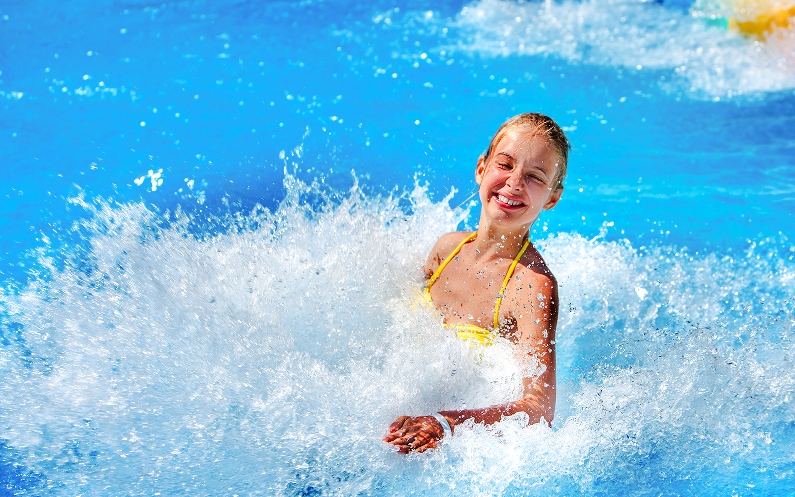 Woman enjoying waves at a water park.