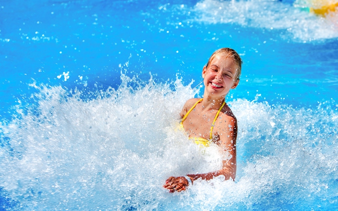 Woman enjoying waves at a water park.