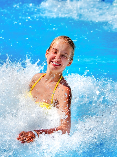 Woman enjoying waves at a water park.