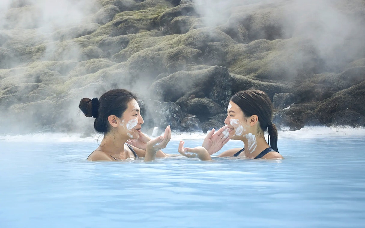 Female tourists applying face masks at Blue Lagoon, Iceland.