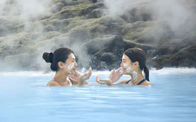 Female tourists applying face masks at Blue Lagoon, Iceland.