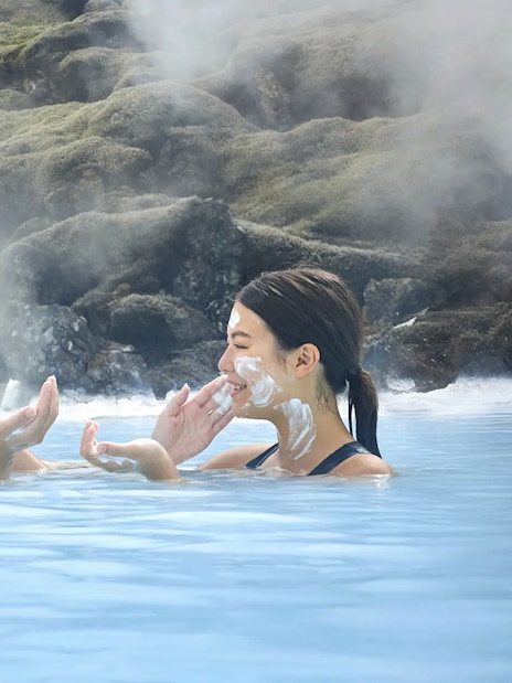 Female tourists applying face masks at Blue Lagoon, Iceland.