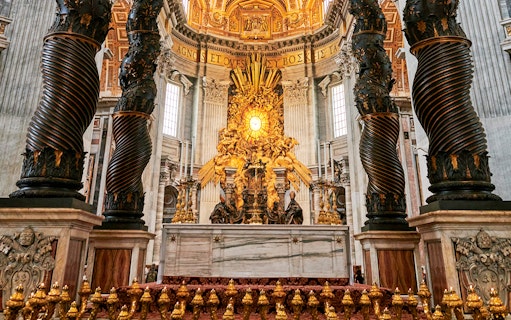 St. Peter's Basilica altar with ornate columns and golden artwork, Vatican City.