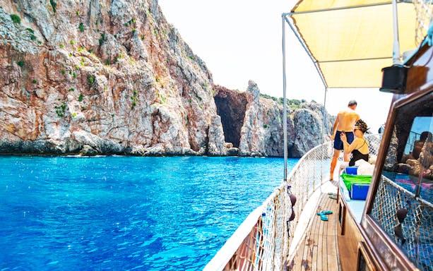 Boat approaching rocky cliffs on a guided tour to Lower Duden Waterfall, Antalya.