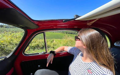 Vintage Fiat 500 drive through Chianti countryside with vineyard view.