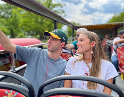Two passengers taking a selfie on a hop-on hop-off bus tour.