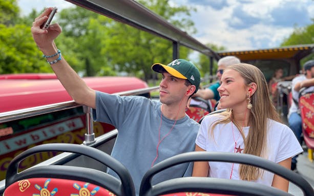 Two passengers taking a selfie on a hop-on hop-off bus tour.