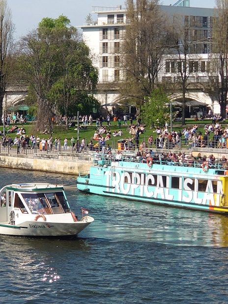 Sightseeing boats with passengers cruising on the Spree River in Berlin Mitte.