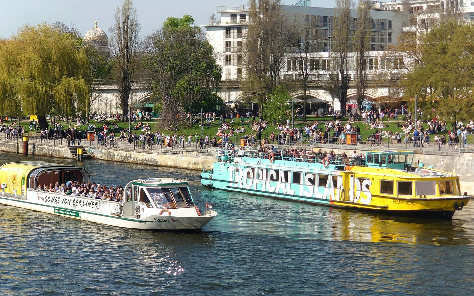 Sightseeing boats with passengers cruising on the Spree River in Berlin Mitte.