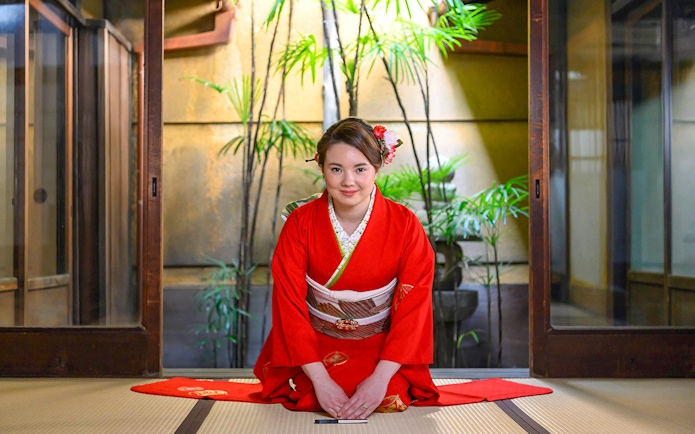 Kimono-clad woman in traditional Kyoto machiya during tea ceremony.