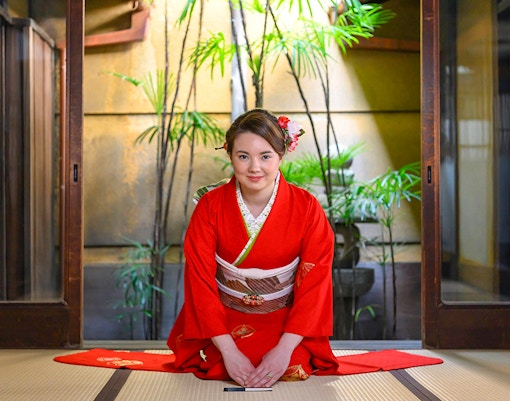 Kimono-clad woman in traditional Kyoto machiya during tea ceremony.