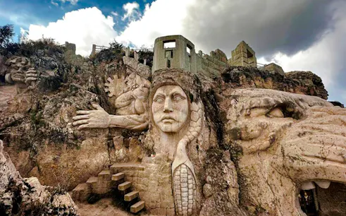 Ancient stone carvings at Abode of the Gods, Cusco, featuring mythical figures and intricate designs.