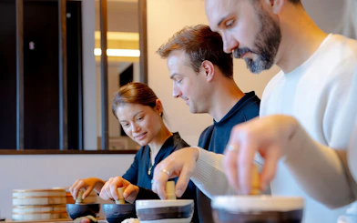 Tourists in Tokyo making matcha with traditional Japanese sweets.