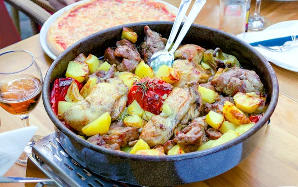 Traditional Croatian peka with mixed meat and vegetables in a baking dish.