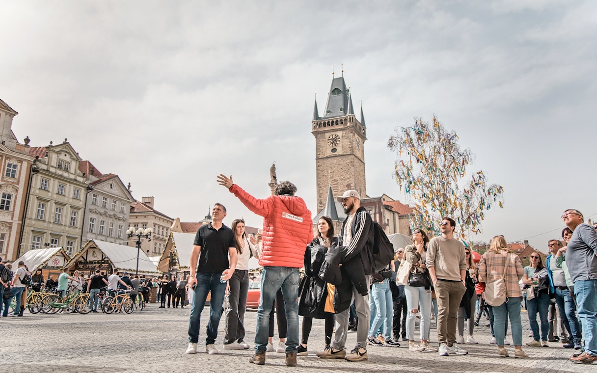 Tour guide leading a group in Prague's Old Town Square near the Astronomical Clock Tower.