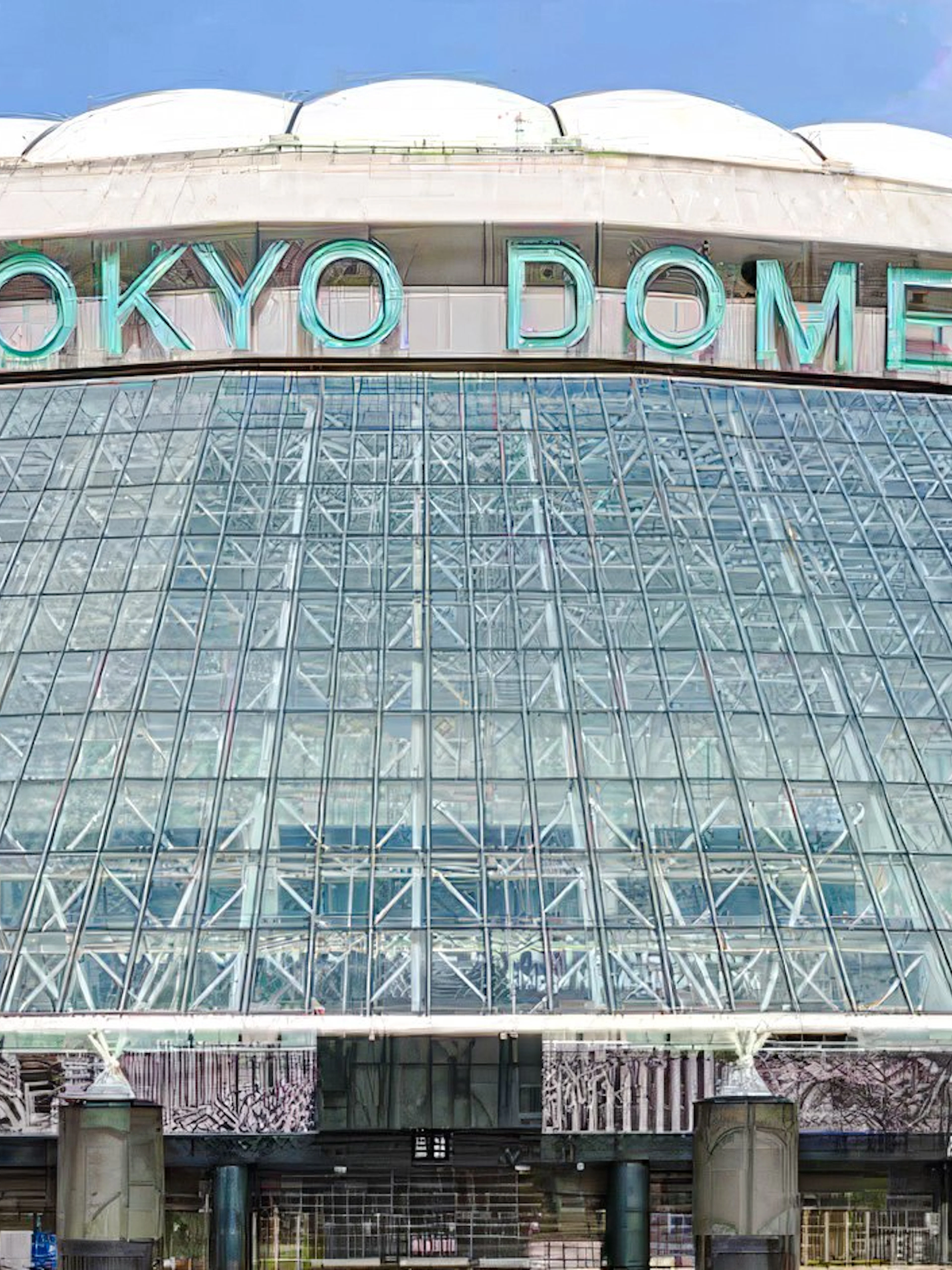 Exterior view of Tokyo Dome with glass facade and entrance.