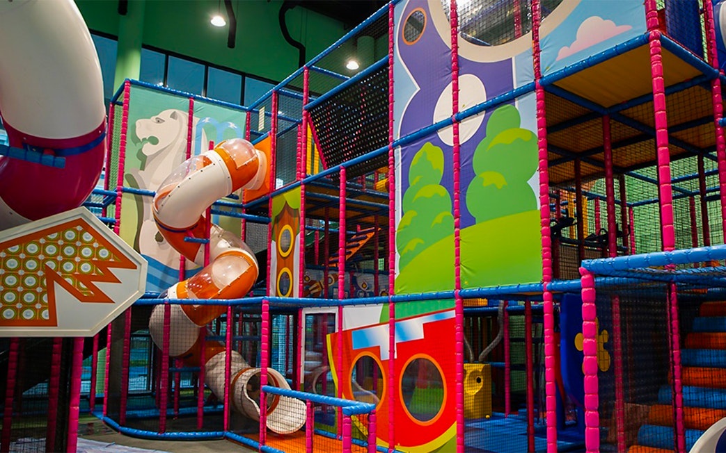 Indoor playground with colorful slides and climbing structures at T-Play Khatib.