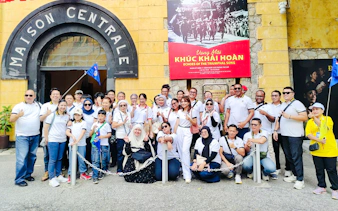 Group of tourists outside Hoa Lo Prison entrance during Hanoi walking tour.