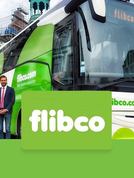 Flibco shuttle bus parked in front of a historic building, offering transport from Frankfurt Hahn Airport to Frankfurt City.