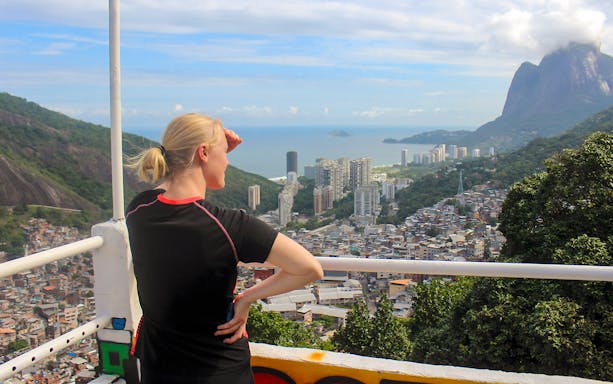 Tourist overlooking Rio de Janeiro from a favela market viewpoint.