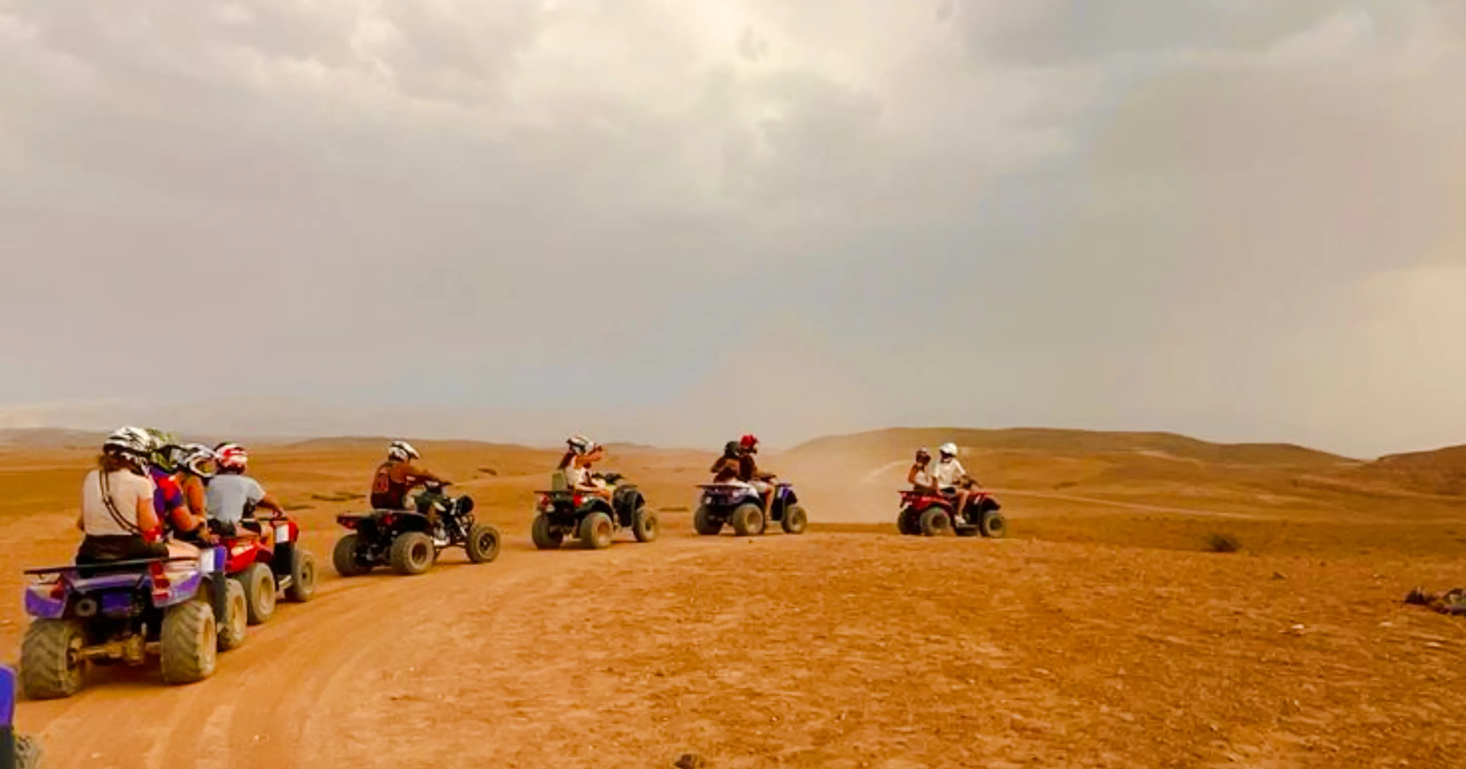 Group riding quad bikes in Marrakech Palmeraie desert.