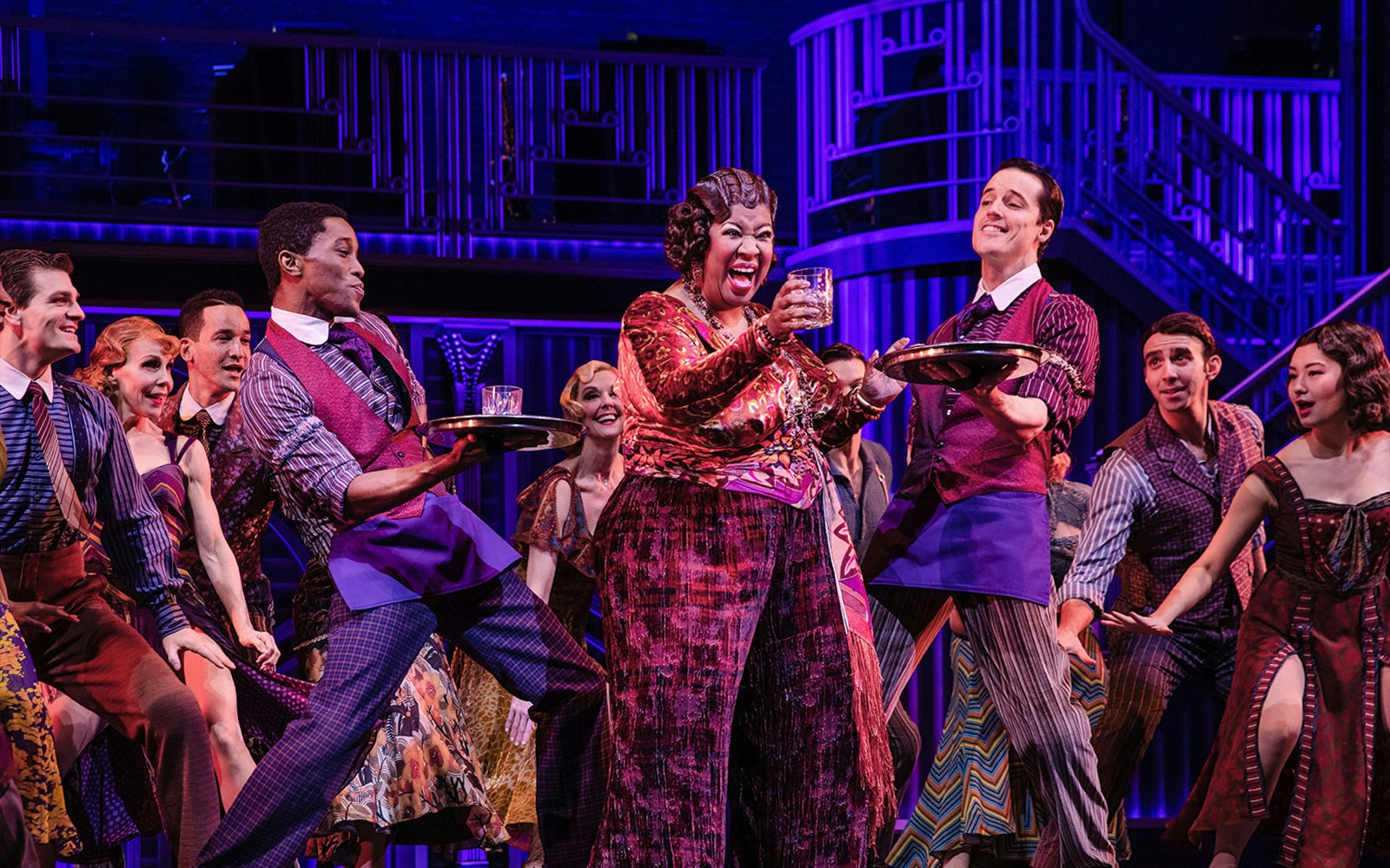 Cast performing a lively scene from "Some Like it Hot" musical on stage.