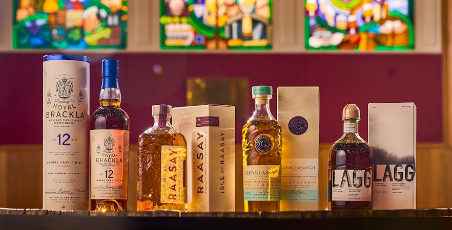 Whisky bottles from Royal Brackla, Isle of Raasay, Glenglassaugh, and Lagg displayed in a tasting catalog.