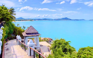Scenic view of Koh Samui coastline with a pavilion and lush greenery.