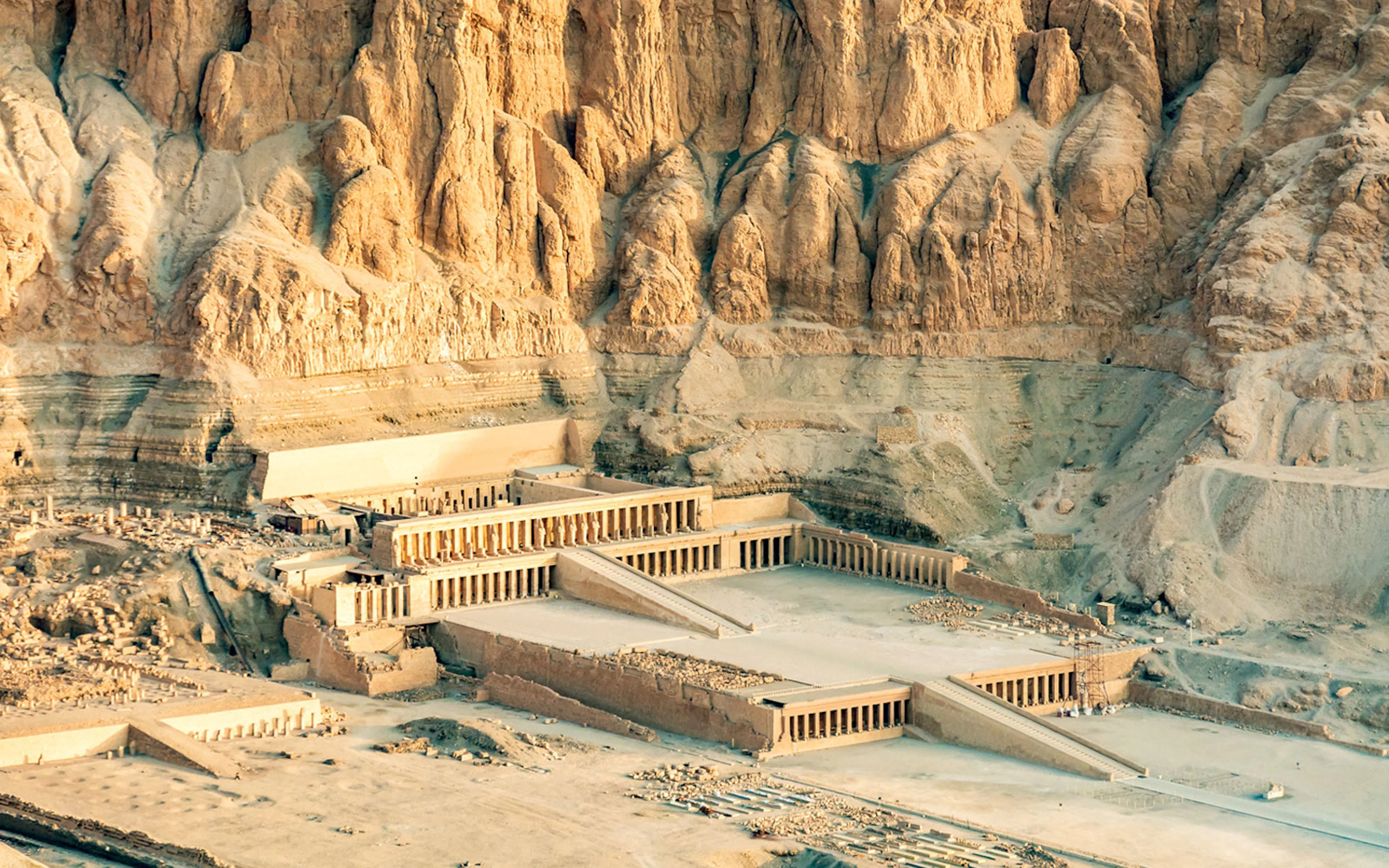 Valley of the Kings Luxor, ancient temple complex, rocky cliffs in background.