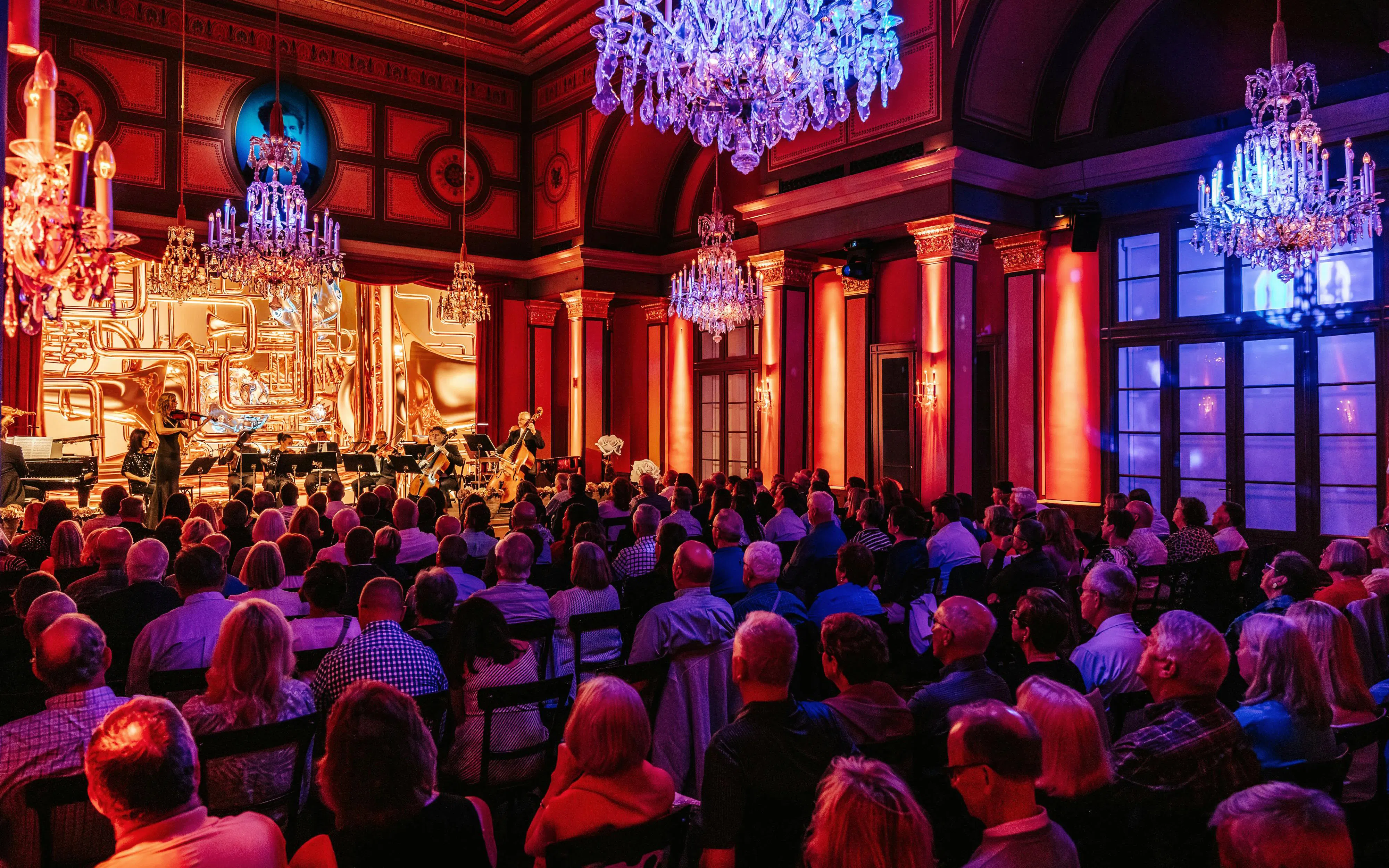 Classical concert in Vienna with orchestra performing in ornate hall.