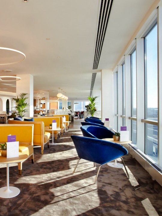 Seating area with large windows at Plaza Premium Lounge, London Gatwick Airport North Terminal.