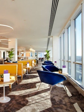 Seating area with large windows at Plaza Premium Lounge, London Gatwick Airport North Terminal.
