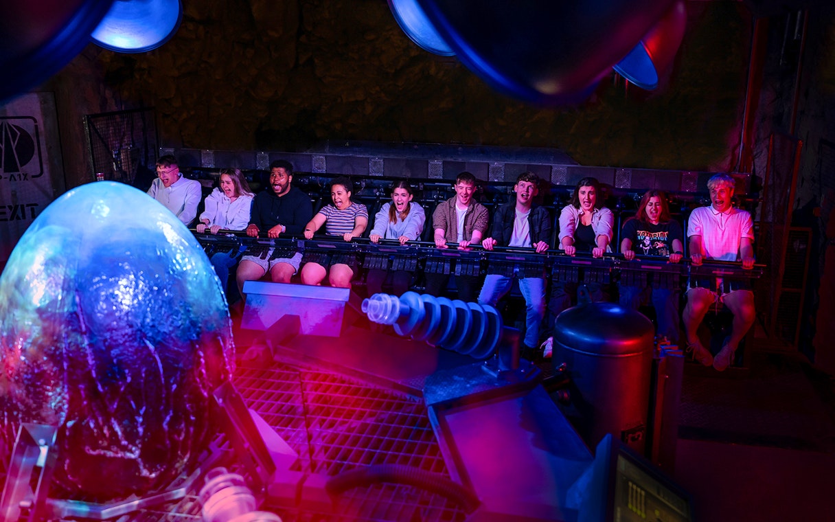 Visitors experiencing Nemesis Sub-Terra ride at Alton Towers with glowing alien egg.