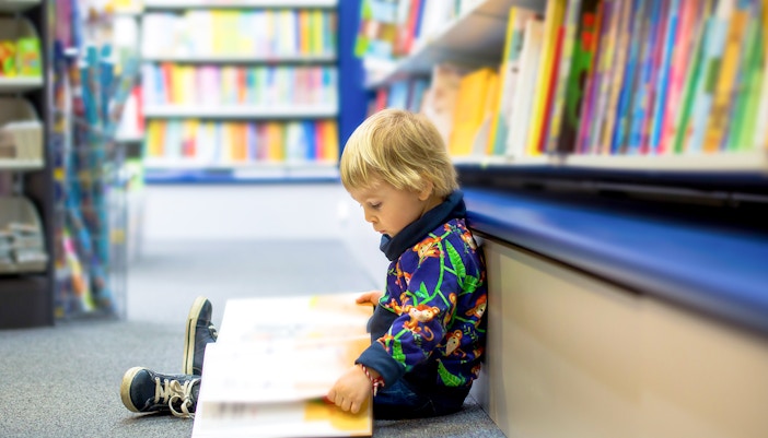 A child engrossed in reading a book at a historic library during a city tour