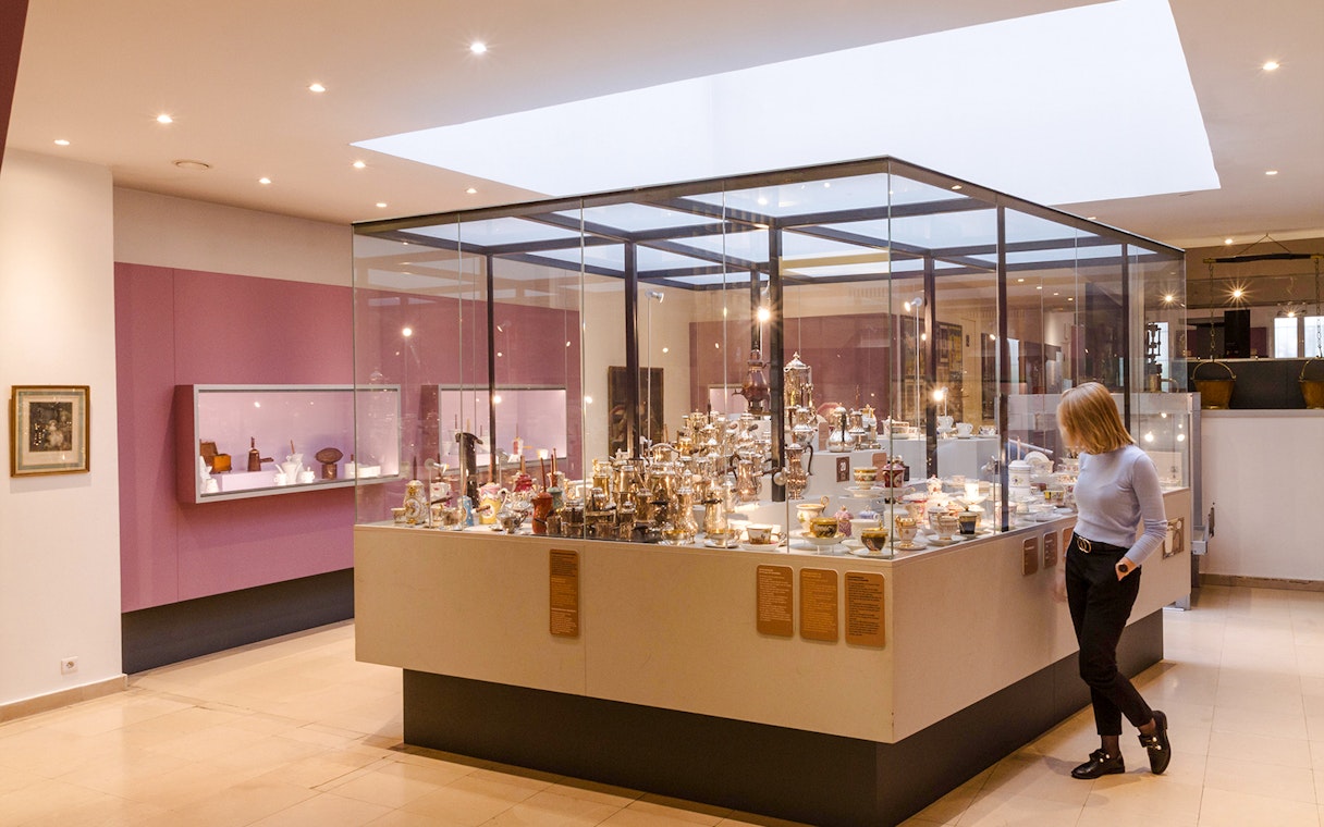 Woman observing chocolate artefacts display at Chocolate Museum Paris.
