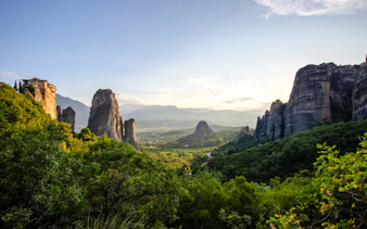 Panoramic view of Meteora monasteries on rocky cliffs in Greece.