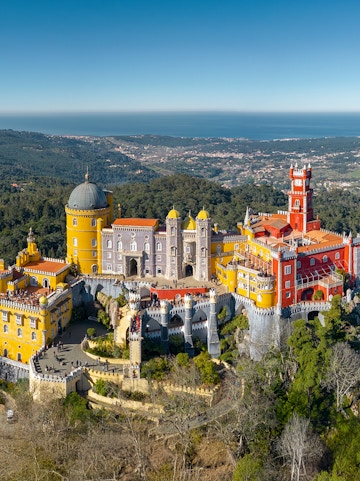 Pena Palace in Sintra, Portugal, with colorful towers and scenic forest backdrop.