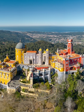 Pena Palace in Sintra, Portugal, with colorful towers and scenic forest backdrop.