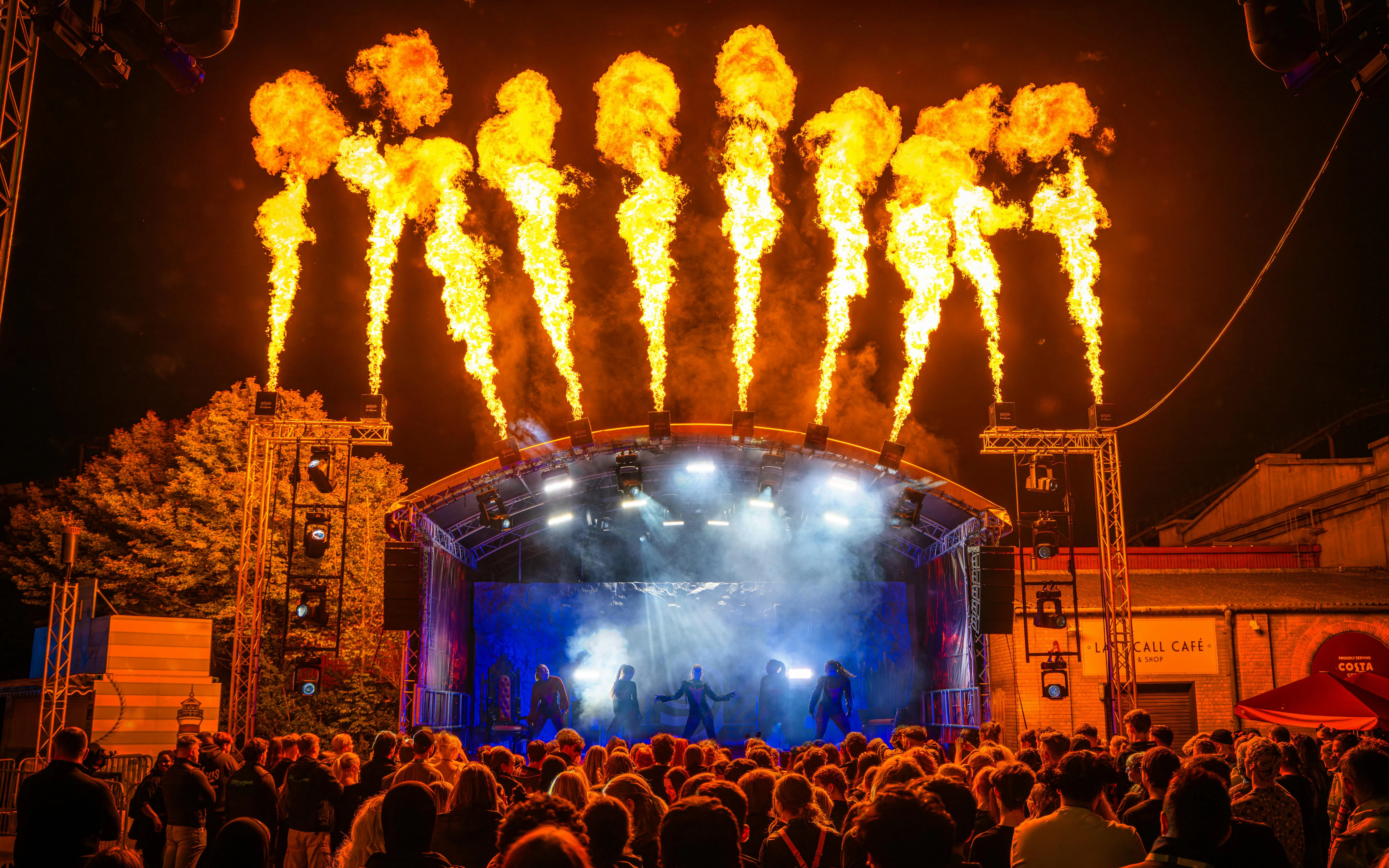 Crowd watching a fiery stage performance at Thorpe Park Fright Nights.