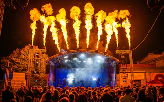Crowd watching a fiery stage performance at Thorpe Park Fright Nights.