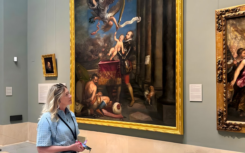 Visitor viewing a large painting at Museo del Prado, Madrid.
