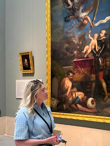 Visitor viewing a large painting at Museo del Prado, Madrid.